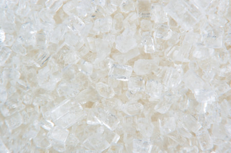 Macro of white sugar crystals of various shapes and sizes with unique facets and contoursの写真素材