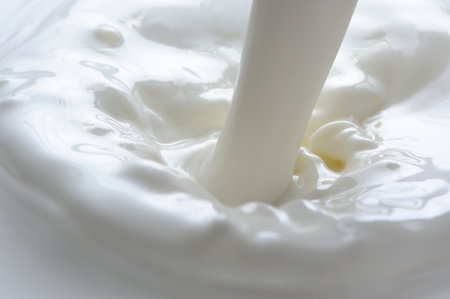 Stream of pouring whole milk close-upの写真素材