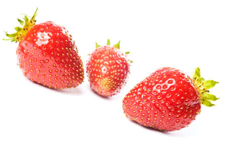 Three fresh ripe red strawberries, isolated on white with soft shadow. Studio shot.