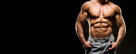 Portrait of strong healthy power fitness handsome athletic man with muscular trained body on black...