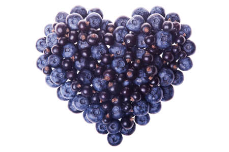 Heart shape made of delicious fresh blueberries and black currants isolated on white background as a design element for love concept - Valentine's Day and Mother's Day. Top view. Studio shot.の写真素材