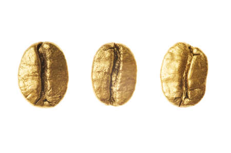 Golden coffee beans isolated on white background - detail. Close up of a gold bean of aroma black caffeine drink ingredient for coffee beverageの写真素材