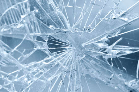 Accident - close-up of broken window. Detail of rifts of cracked glass. Blue background.