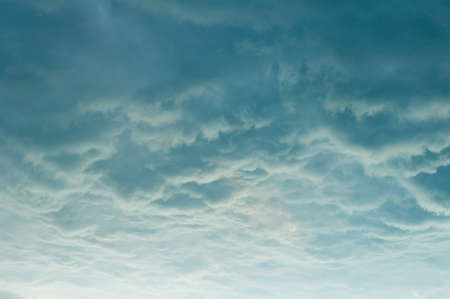 Beautiful blue sky background. Soft white clouds with patterns at sunset.