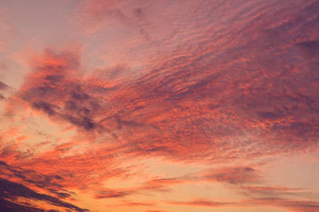 Fire sky background. Soft clouds with the hint of the sun at sunset. Many orange tones and patterns...