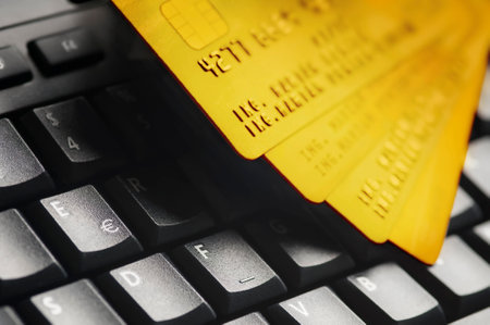 Four golden credit cards on black computer keyboard.  E-commerce data and ebanking protection, internet and finance security concept.の写真素材