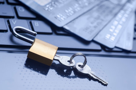 Unlocked padlock, keys and four credit cards on blue computer keyboard. E-commerce data and ebanking...