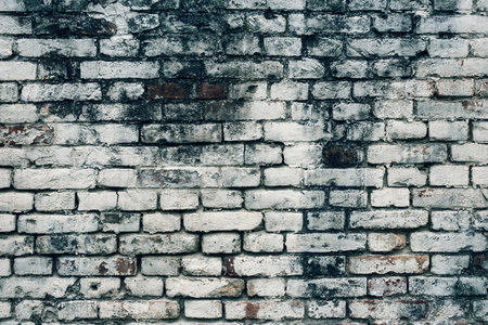 Aged white painted brick wall texture. Old textured grunge wall surface background pattern of masonry. Cracks and black stains.の写真素材