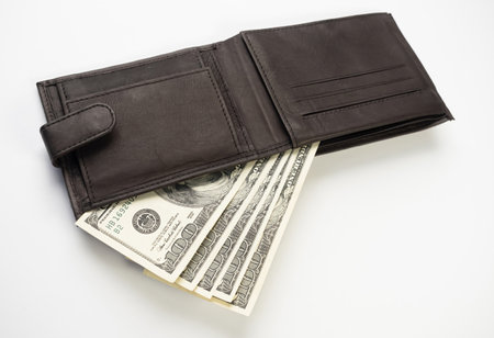 Leather wallet full of money on white background - fan of one hundred US banknotes with president...