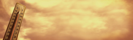 Wooden thermometer showing high temperature over 44 degrees Celsius on hell hot day. Orange sky with clouds background. Panorama. Concept of heat wave, warm weather, global warming, climate change.の写真素材