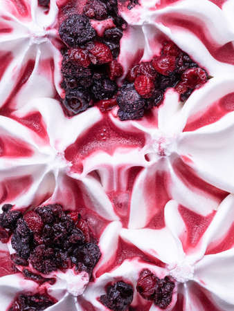 Frozen Yoghurt flavour gelato - full frame detail. Close up of white surface texture of Yoghurt Ice cream covered with pieces of red forest fruit.の写真素材