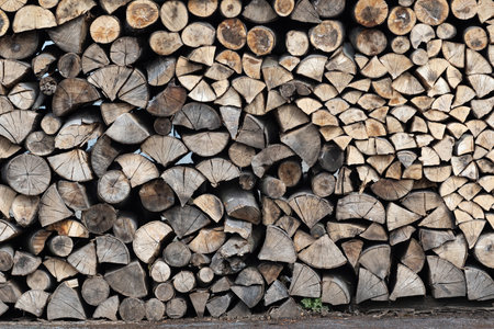 Dry firewood stacked in a pile, chopped wood for winter heating fuel of the fireplace. Natural wood background.の写真素材