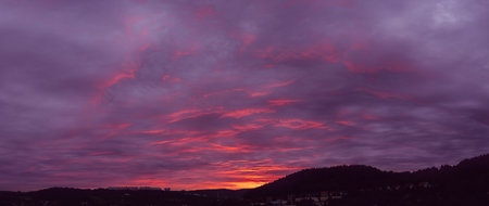 Silhouette of landscape on dramatic dusk sky with clouds. Mysterious abstract heaven background pattern texture at sunset. Wide banner panorama.の写真素材