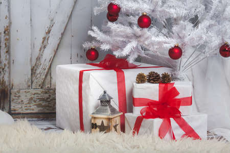 Teddy bear with an Angel and the gifts sitting on wooden vintage background gate. Christmas tree