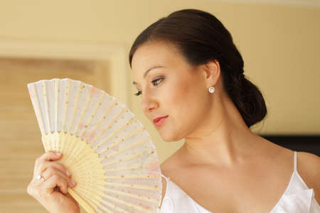Asian woman fanning herselfの写真素材