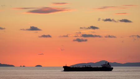 A freighter on the sea at sunsetの写真素材