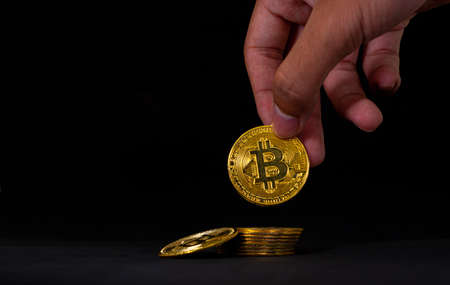 Golden bitcoin in the middle of pile, Bitcoin with blue graph on black background. Crypto currency...