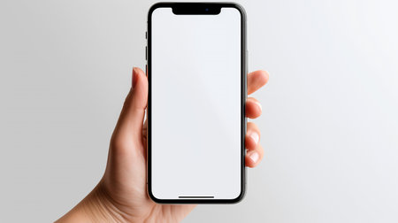 Mockup image of a hand holding a black smartphone with blank white screen isolated on white backgroundの素材