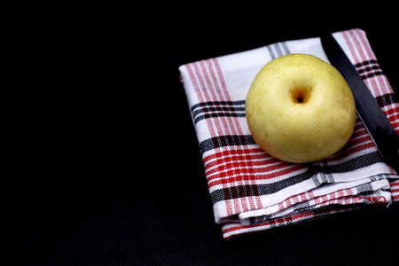 Image of pear and knife on the duster in black backgroundの写真素材