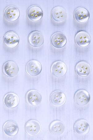 white buttons on a white wood background
