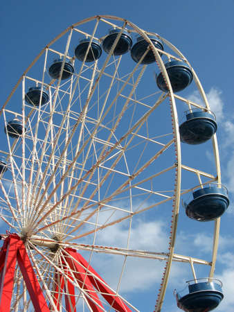 a giant Ferris wheel stands against a brilliant blue sky background on summer day.の写真素材
