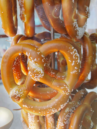 Fresh baked soft pretzels for sale in a vendor's glass case at a carnival.の写真素材