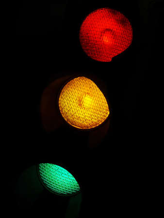 Red, Yellow, and Green traffic lights in the dark.の写真素材