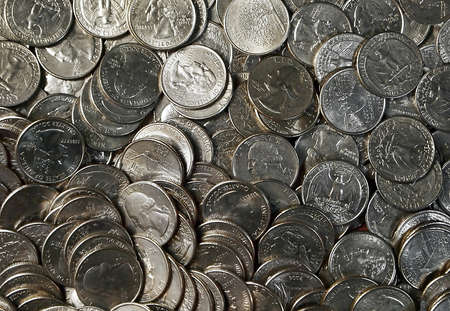 A tray full of American quarters laid out flat for a money themed background image の写真素材