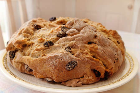A freshly baked loaf of Irish Soda Bread rests on a table, ready to serve.の写真素材