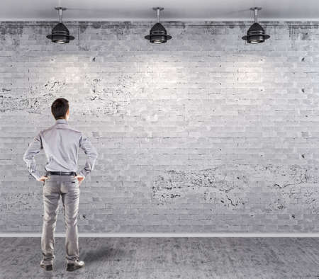 young attractive business man in front of a vintage old blank wallの写真素材