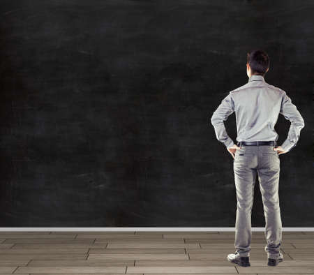 young attractive business man in front of a vintage old blank wallの写真素材