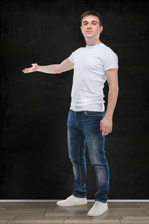 portrait of casual young attractive man standing in front of a vintage wallの写真素材