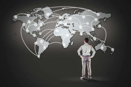 business man standing in front of world map backgroundの写真素材