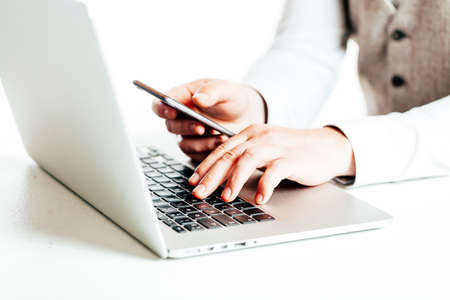 Close up image of multitasking business man using  a laptop and mobile phoneの写真素材