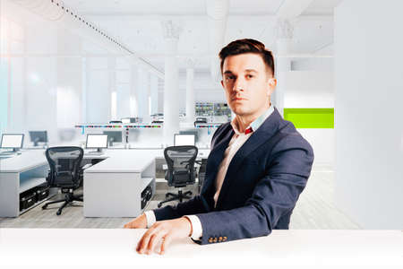 Attractive businessman with modern suit sitting against modern office view