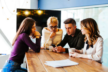 Casual discussion between coworkers in modern office roomの写真素材