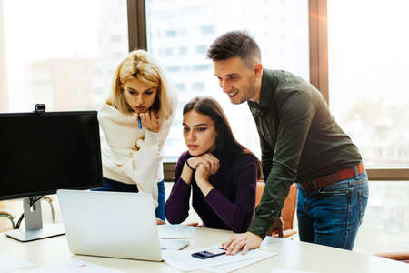 Coworkers meeting around laptop in conference roomの写真素材