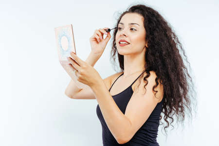 Young beautiful model with curly hair using beauty products