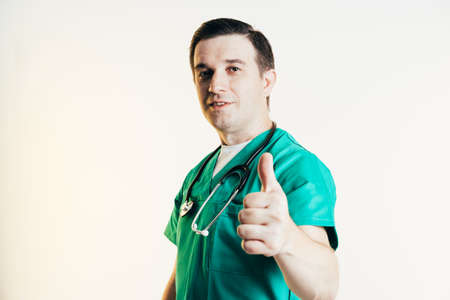 Young male doctor in uniform posing in studio