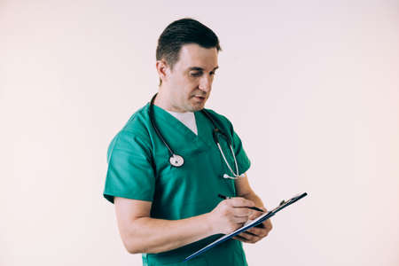 Young male doctor in uniform posing in studio