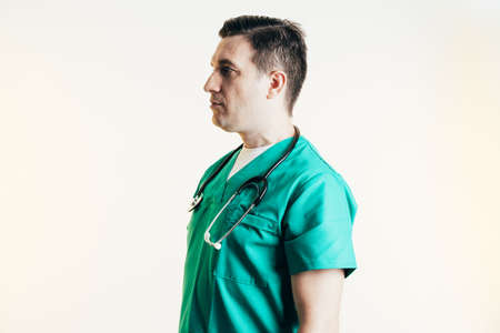 Young male doctor in uniform posing in studio