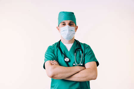 Young male doctor in uniform posing in studioの写真素材
