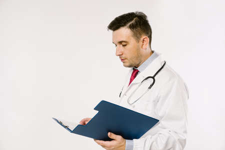 Young man doctor in uniform  posing in studioの写真素材