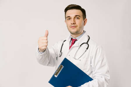 Young man doctor in uniform  posing in studioの写真素材