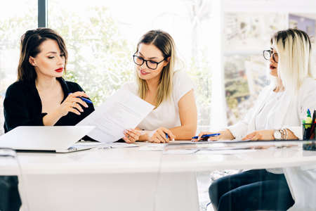 Young professional team. Creative people sittting at a table having a brainstorm meeting in the...