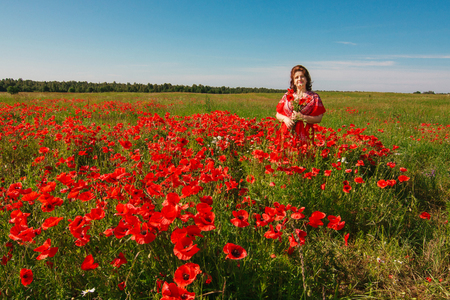 Portrait smiling happy old Elderly woman having fun, walking in a field with poppy flowers. Healthcare lifestyle senior lady relax in spring. Female in summer time.の写真素材
