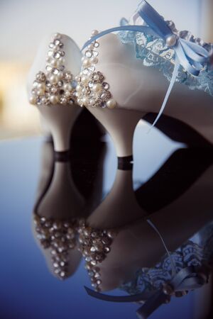 Bride's shoes with reflection from the tableの写真素材
