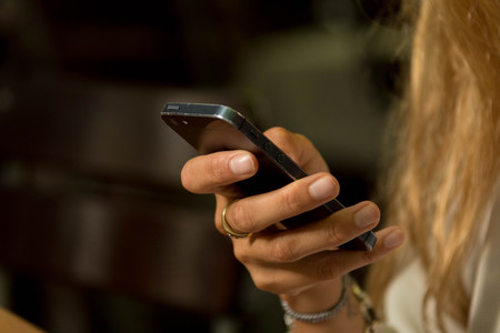 Woman with Blond Hair Holding Smartphone in Right Handの写真素材