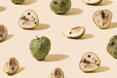 Pattern created from fresh exotic cherimoya slices on ivory background. Flat lay view.の写真素材