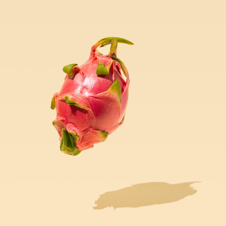 Distinctive superfood dragons fruit with vibrant magenta skin color on unique champagne color backgroundの写真素材